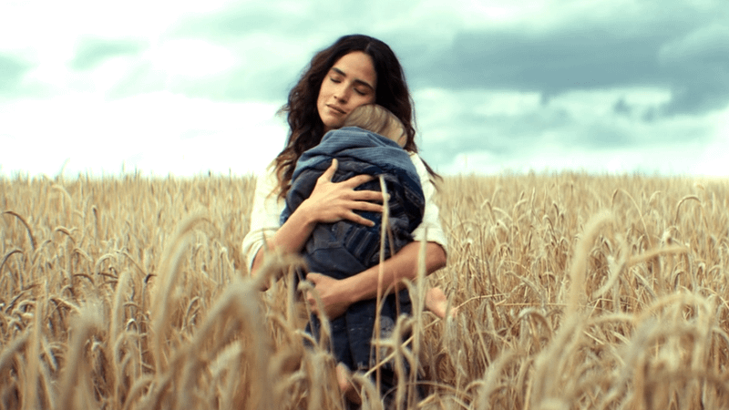 Adria Arjona as Bix Caleen holding a baby in Andor