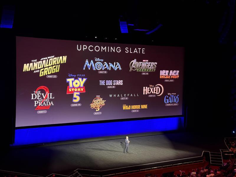 Upcoming slate with title cards for The Mandalorian and Grogu, The Devil Wears Prada 2, Toy Story 5, Super Troopers 3, The Dog Stars, Moana, Avengers: Doomsday, Wild Horse Nine, Hexed, Ice Age: Boiling Point, Gatto.