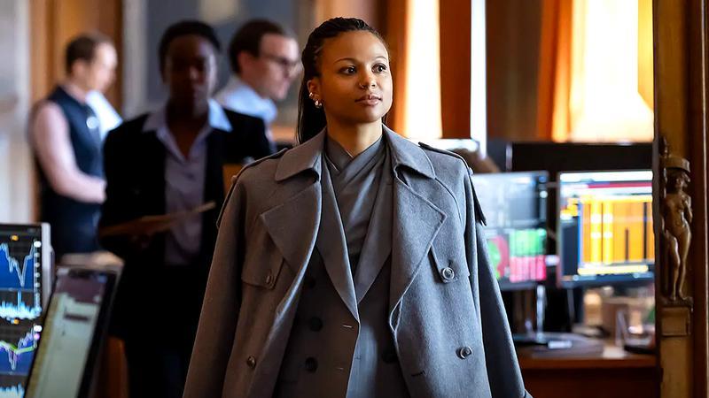 Myha'la as Harper in a large grey coat in Industry