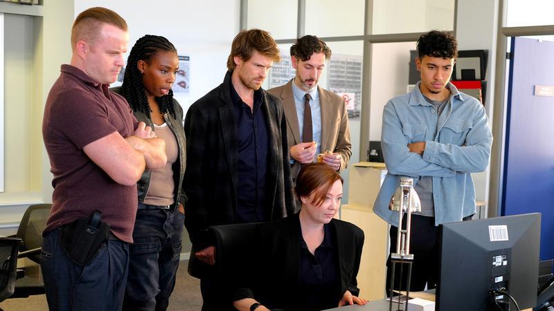 Cast of Maigret staring at a computer screen.