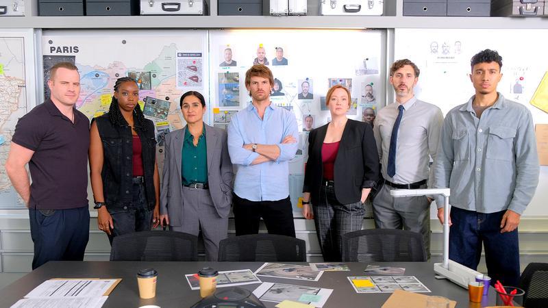 Cast of Maigret staring at the camera in front of a investigation board.