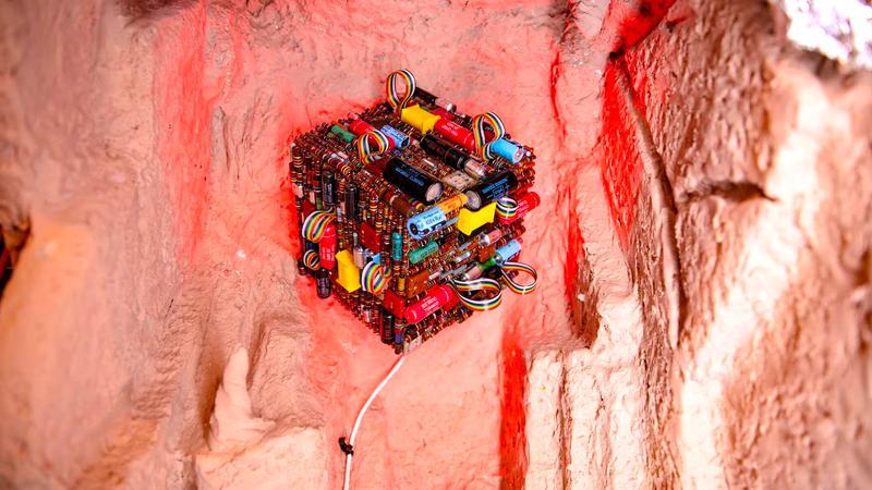 Meow Wolf Los Angeles work in progress art of a wired cube on a cave wall.