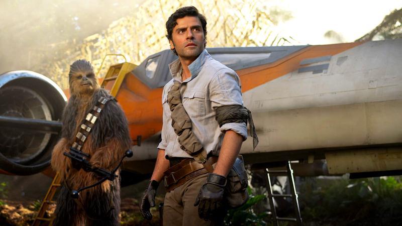Oscar Isaac as Poe Dameron standing next to Chewbacca in Star Wars: The Rise of Skywalker
