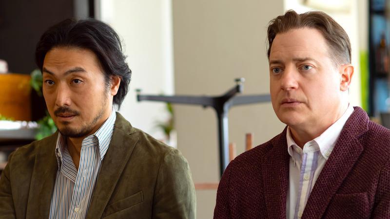 Shinji and Phillip sitting down side by side in Rental Family.