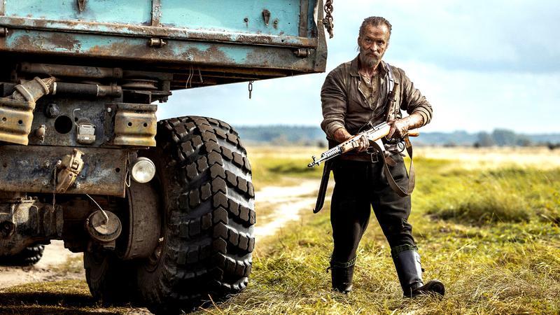 Sisu: Road to Revenge actor next to truck.