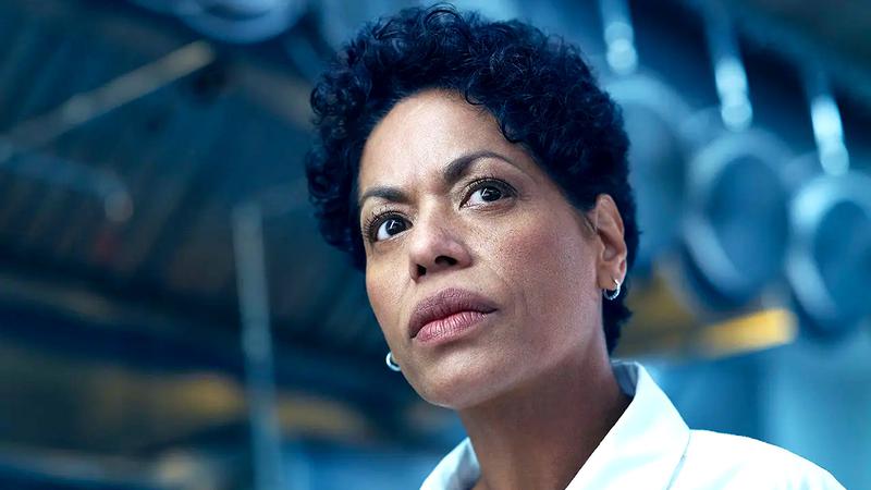 Liza Colon-Zayas as Tina standing in a kitchen in The Bear