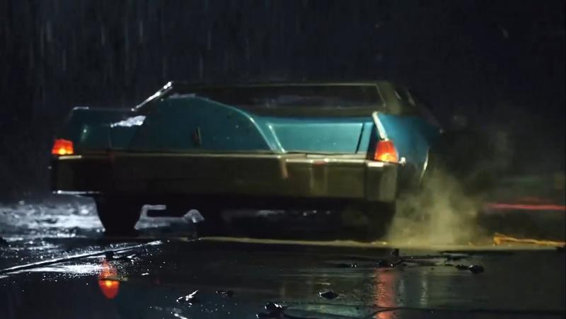 The rear-end of a blue station wagon in the rain in Dynamic Duo