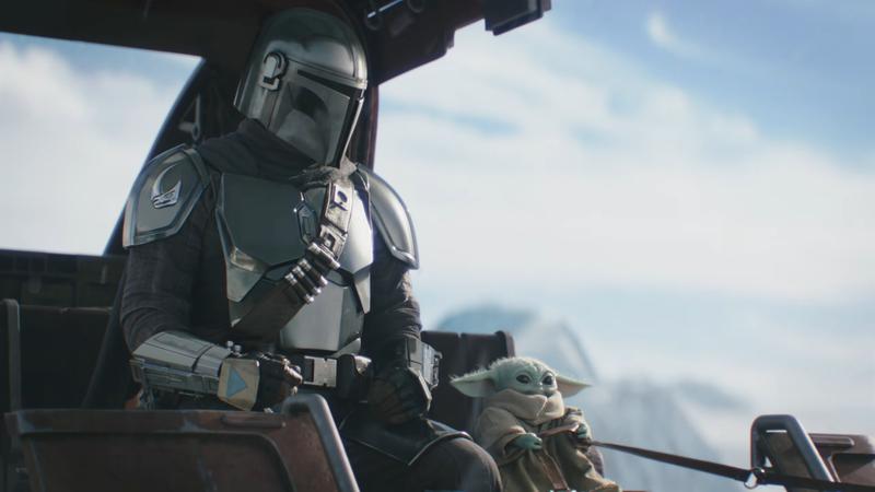 The Mandalorian sitting next to Grogu in a snowy environment in The Mandalorian & Grogu.