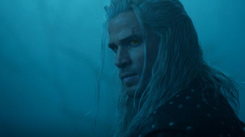 Liam Hemsworth as Geralt of Rivia looking over his should in the fog in The Witcher