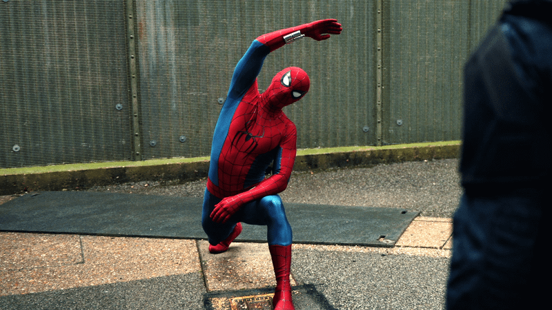 Spider-Man stretching in front of DODC officers.
