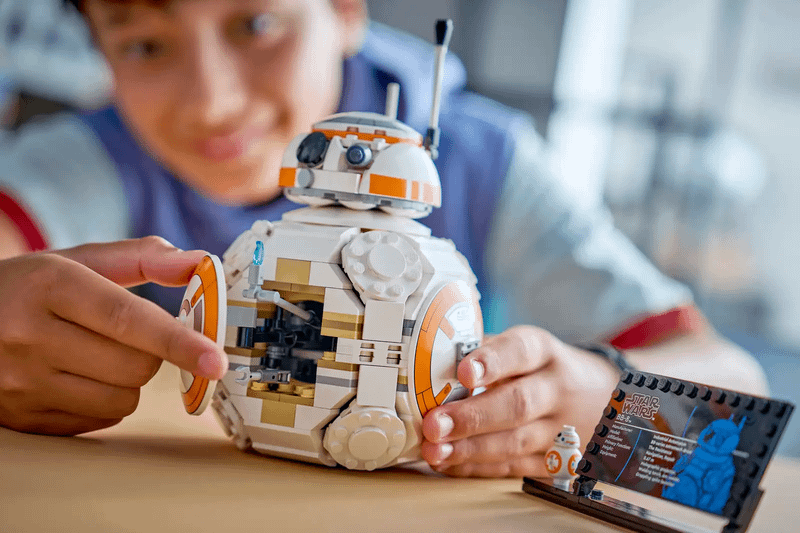 A small boy playing with the new BB-8 LEGO set