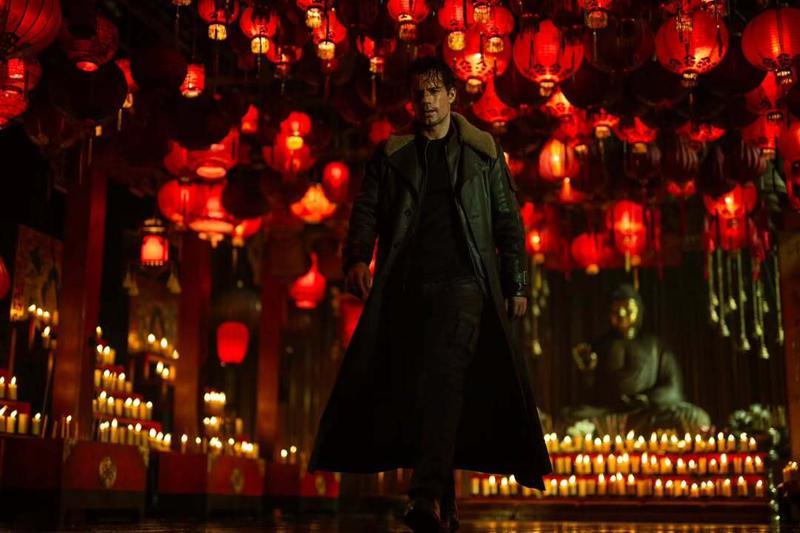 Henry Cavill as Highlander with red lanterns and candles behind him.