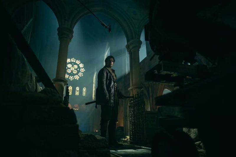 Henry Cavill's Highlander in a cathedral setting with a sheathed katana.