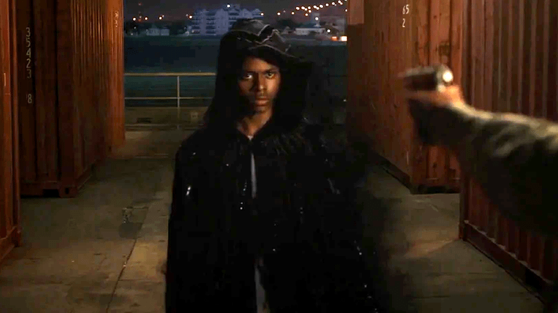 Aubrey Joseph as Tyrone Johnson, staring down an assailant with a gun in Freeform's Cloak & Dagger.