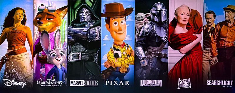 Disney banner from CinemaCon showing live-action Moana, Nick Wilde, Judy Hopps, Doctor Doom, Woody, Grogu, the Mandalorian, Miranda Priestly, and characters from 'Wild Horse Nine.'