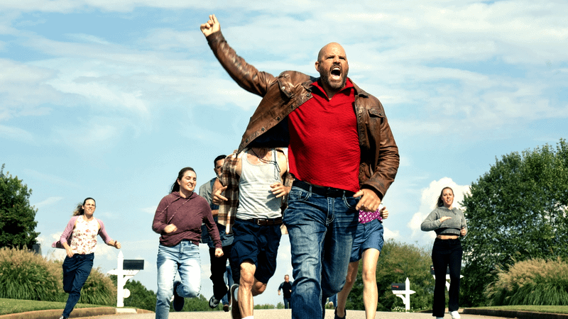 A group of white people running, chasing someone not visible on camera, from 