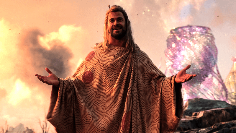 Chris Hemsworth as Thor with his arms open in Love and Thunder.