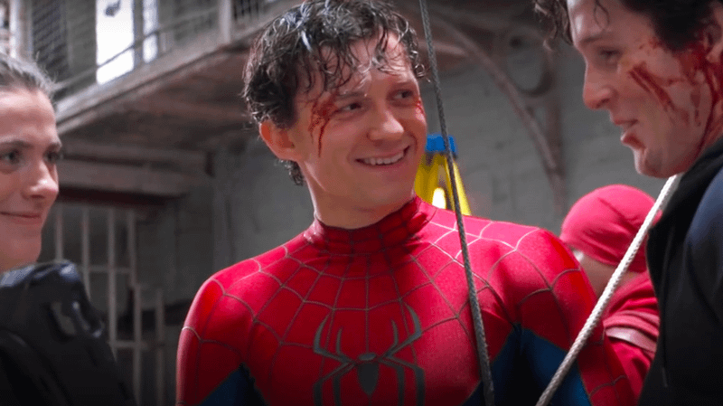 Tom Holland smiling in Spider-Man costume in prison set on 'Spider-Man: Brand New Day' set.