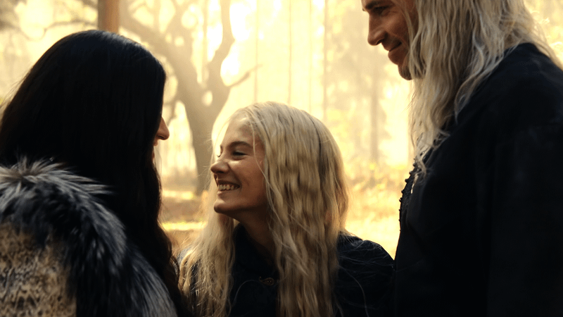 Yennefer, Ciri, and Geralt standing and laughing together in The Witcher