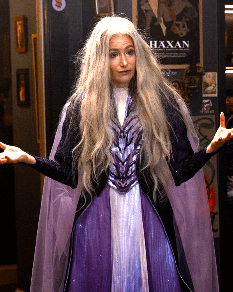 Kathryn Hahn as Agatha Harkness in a purple dress with her hands out in Agatha All Along