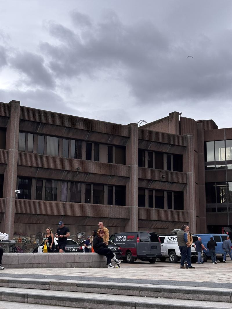 brown building with news vans outside on Clayface set
