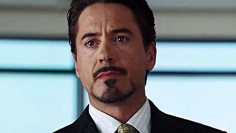 Tony Stark standing at a podium in Iron Man.
