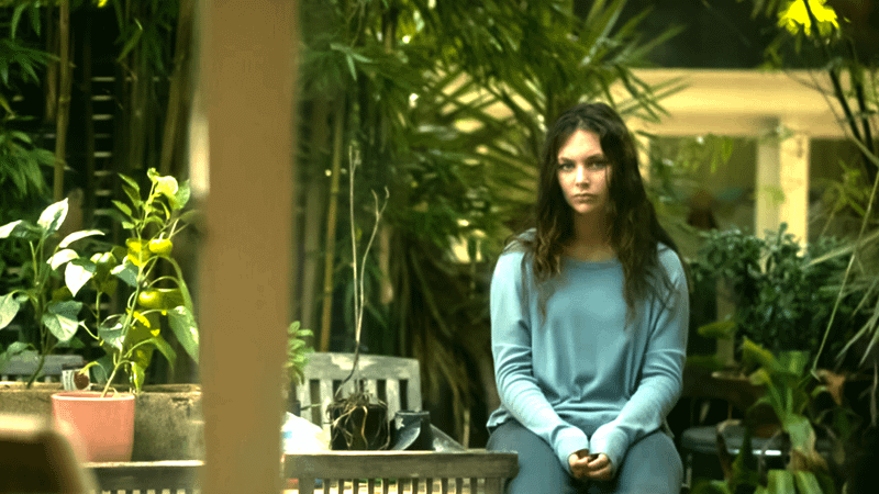 Coco Jack Gillies as Ivy Moon sitting on a chair in a backyard in Playing Gracie Darling