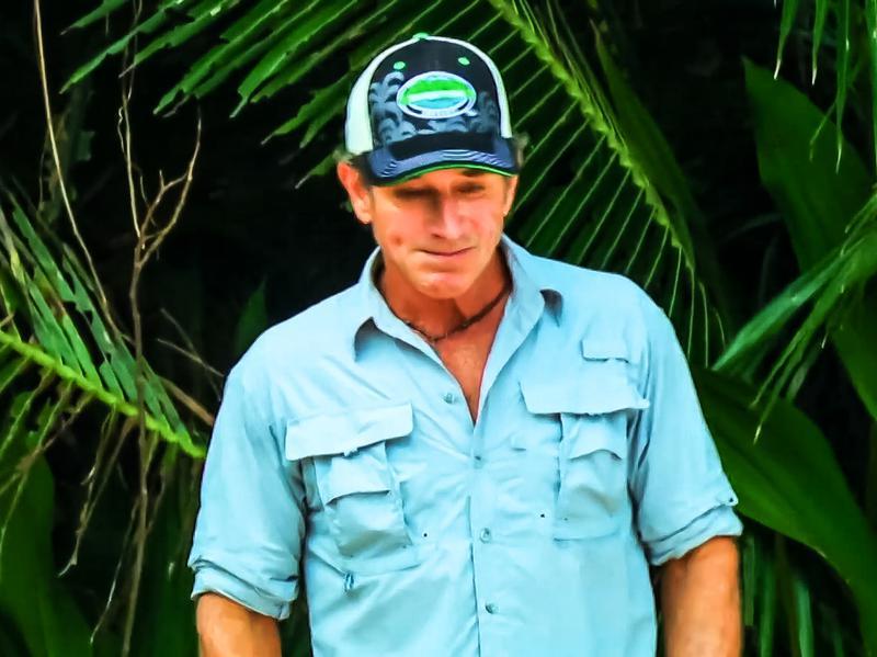 Jeff Probst wearing a blue shirt and blue Survivor hat in Survivor 48