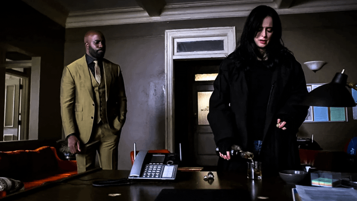 Jessica Jones and Luke Cage standing in a room.