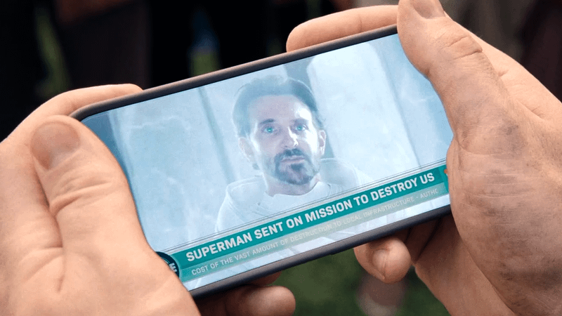 Superman holding the cell phone with Bradley Cooper as Jor-El on the screen.