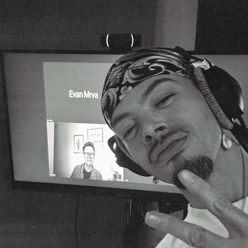 Kirs Kollins posing in front of a Zoom screen 