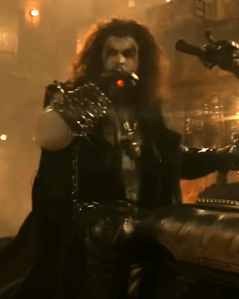 Lobo on a bike with a lit cigar in his mouth.
