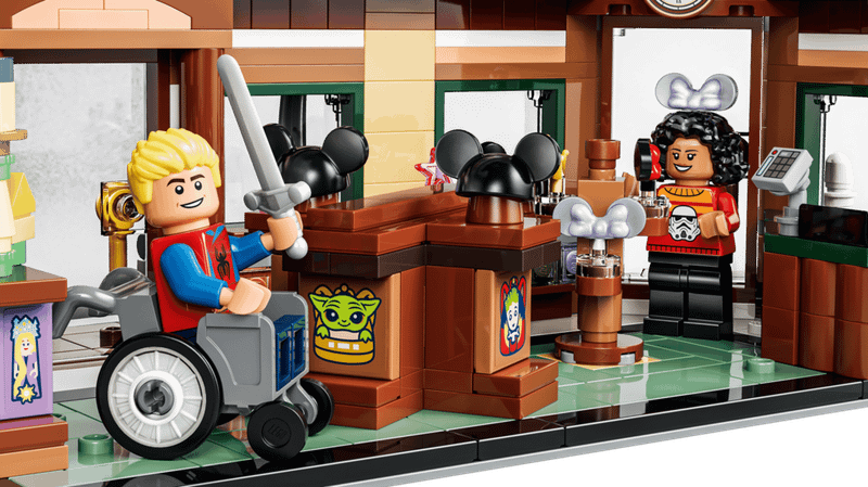 A Minifigure wearing a Spider-Man shirt and holding a sword, and another Minifigure wearing a Stormtrooper sweater in the Main Street, U.S.A. Emporium.