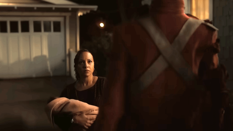 A Manhunter shape shifting in front of a woman.