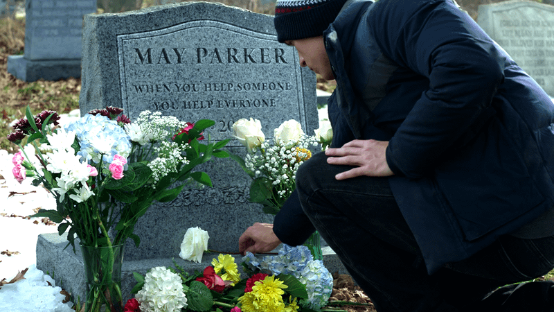 Peter at Aunt May's tombstone in Spider-Man: No Way Home.