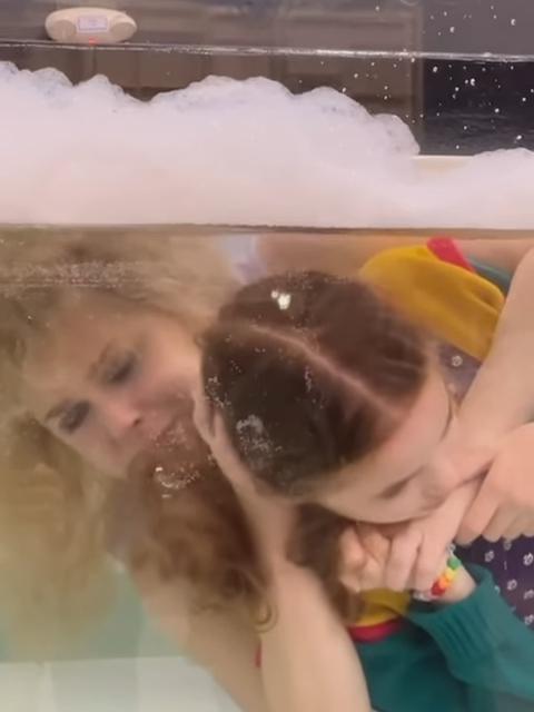 Nell Fisher as Holly and Cara Bouno being held under water in Stranger Things