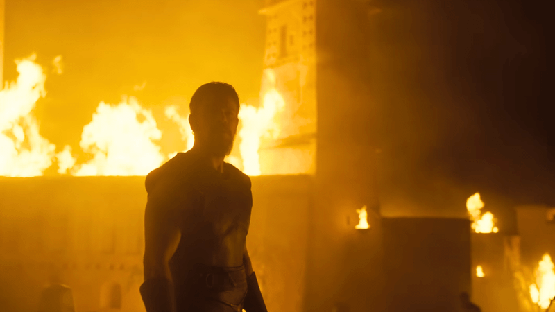 Matt Damon as Odysseus with Troy burning in The Odyssey.