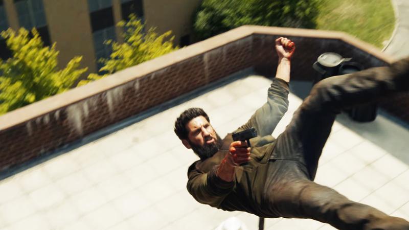 Jon Bernthal as Frank Castle jumping from a building and shooting in 'The Punisher: One Last Kill.'