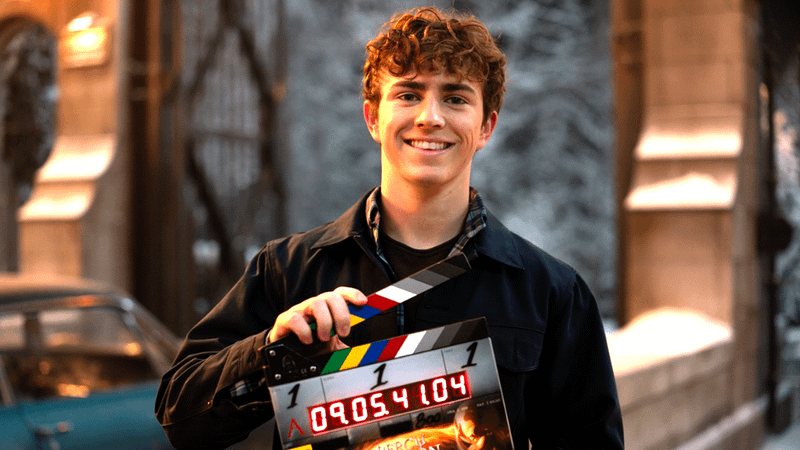 Walker Scobell holding a clapper marking the start of production on