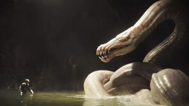 Din Djarin with his helmet off facing a dragonsnake in the water.