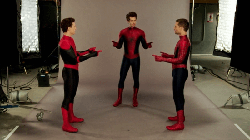 Tom Holland, Andrew Garfield and Tobey Maguire Spider-Men pointing at each other.