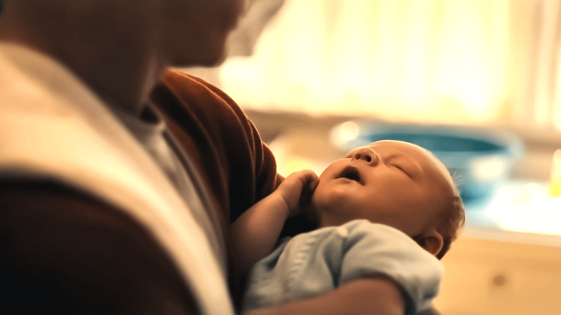 Steve Rogers holding his baby son in Avengers; Doomsday.