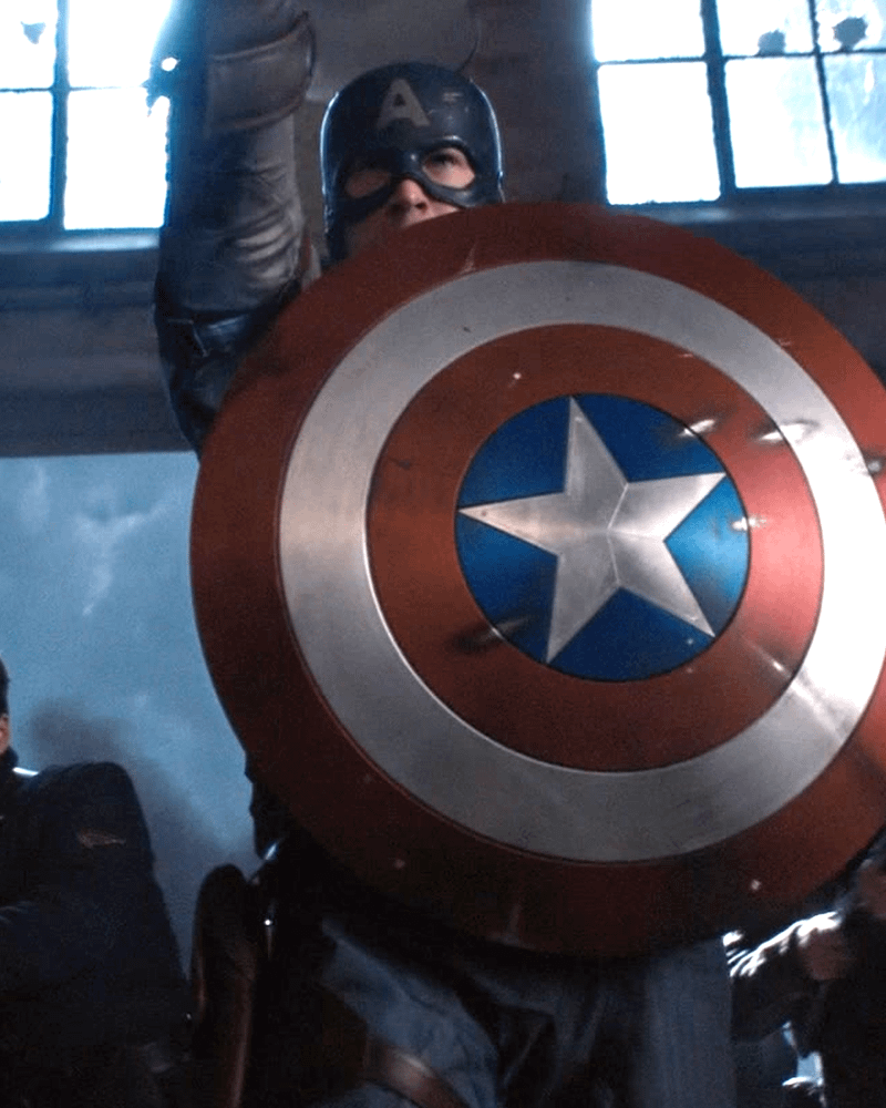 Chris Evans as Captain America holding shield.