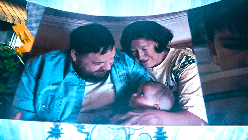 Images of Clark Kent as a child with in the arms of his parents.