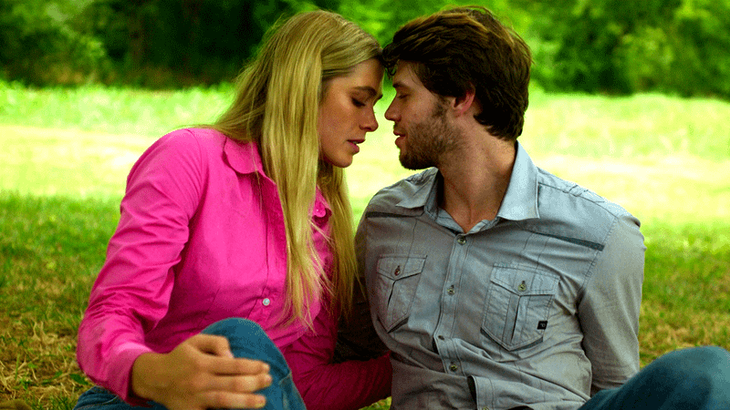 Colin Ford as Cody Gunner leaning in to kiss Rose Reid as Ali Daniels