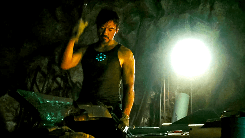 Robert Downey Jr. as Tony Stark forging Iron Man's helmet in Iron Man.