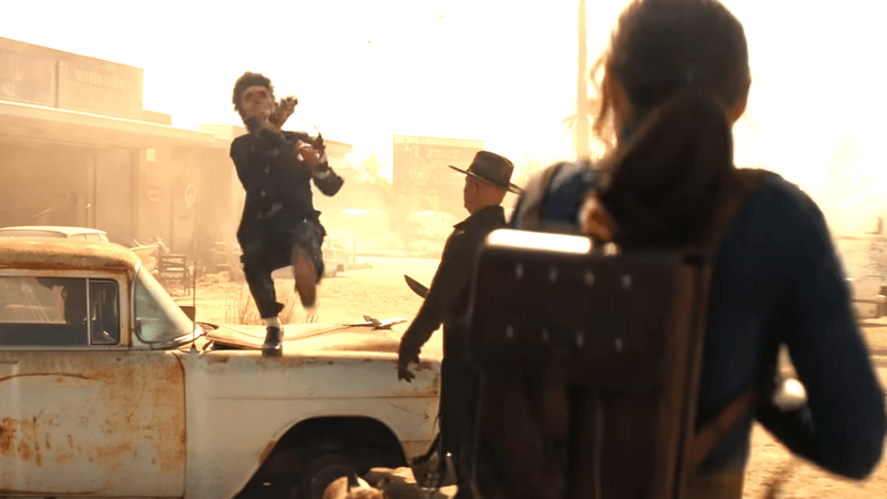 A shot of Ella Purnell's Lucy from behind shooting a mutant Elvis impersonator