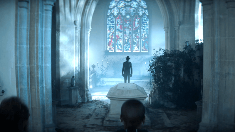 A shadowy figure standing beside a casket in VisionQuest.