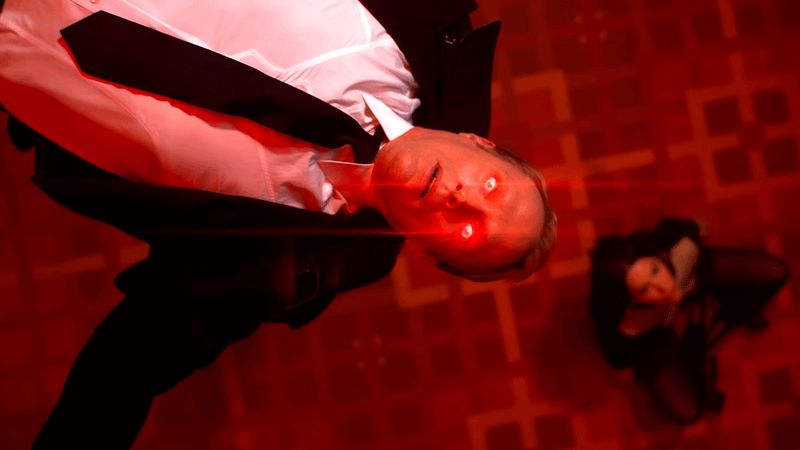 Vision floating with red eyes with a woman below him.