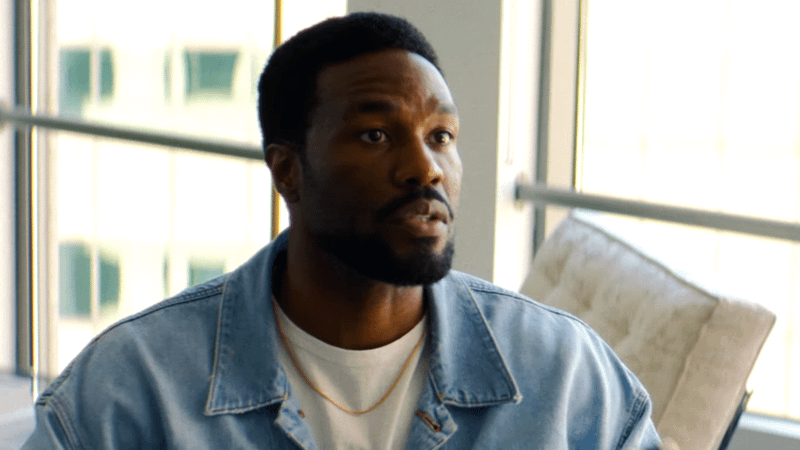Yahya Abdul-Mateen II as Simon Williams sitting in a bright office in Wonder Man